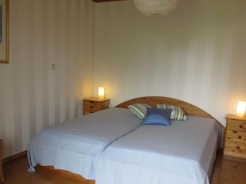 a bedroom with a large bed with two lights on it at Nice apartment in Gersfeld in Gersfeld