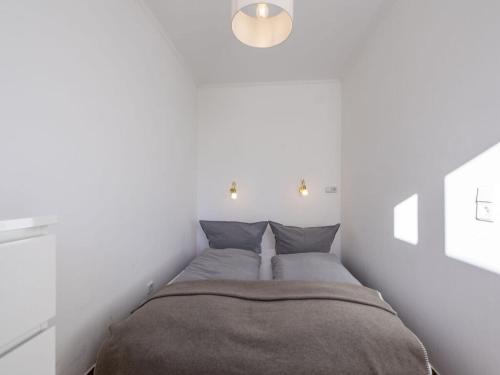 een slaapkamer met een bed met 2 kussens bij Holiday apartment Leo by the lake in Bad Wiessee