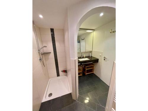 een badkamer met een wastafel en een spiegel bij Nice apartment in Hopfen am See in Hopfen am See