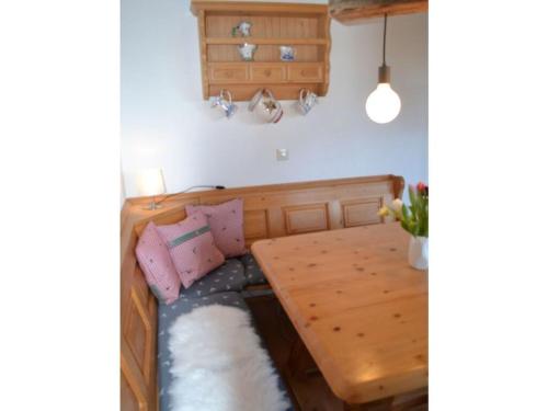 Cette chambre comprend un lit en bois et une table en bois. dans l'établissement Lively apartment in Bad Wiessee, à Bad Wiessee