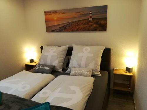 um quarto com duas camas e um farol na parede em Charming apartment in Norden em Norden