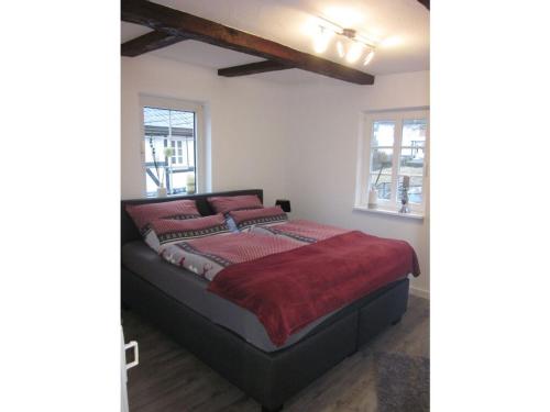 een slaapkamer met een bed met rode lakens en ramen bij Majestic apartment in Olsberg in Olsberg