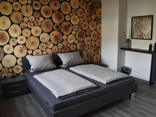a bed in a room with a wall of logs at Nice apartment in Neuenkirchen in Neuenkirchen