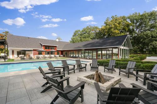 a pool with chairs and a fire pit next to a house at Apple Blossom Resort By Dwell Vacations in New Buffalo