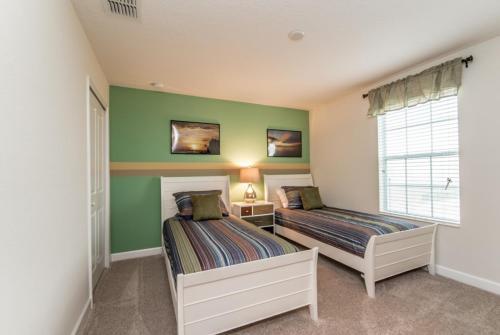 duas camas num quarto com paredes verdes em Enchanting Escape Private Pool SPA Games Room em Orlando