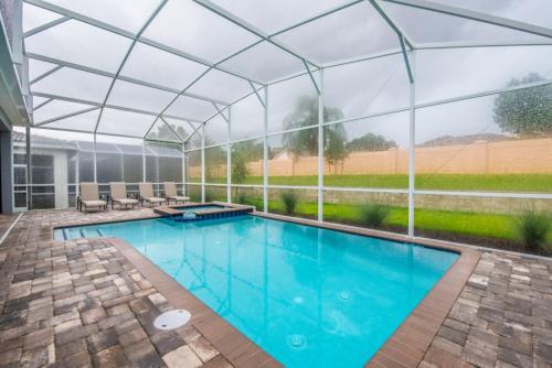 uma piscina interior com telhado de vidro em Enchanting Escape Private Pool SPA Games Room em Orlando