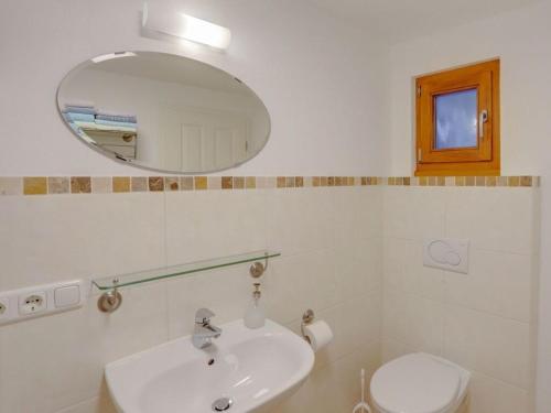 a bathroom with a sink and a mirror and a toilet at Lovely apartment in Berchtesgaden in Berchtesgaden