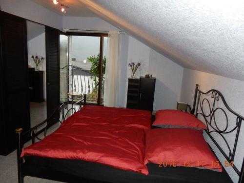 a red bed in a room with a window at Holiday apartment Moselle Panorama in Enkirch