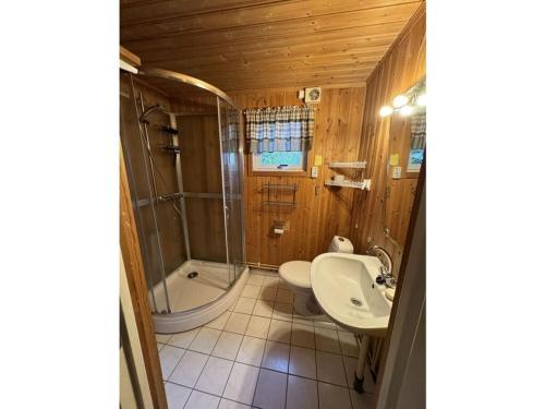 een badkamer met een toilet, een wastafel en een bad bij Holiday home Villa Sjöängen in Lammhult