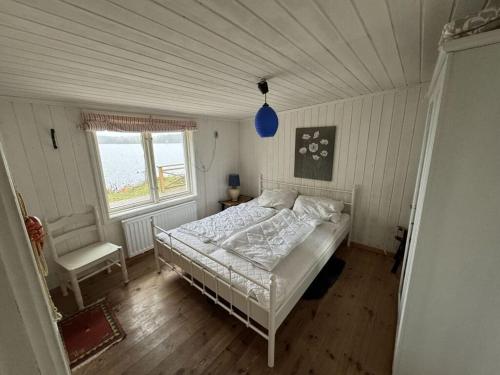 een slaapkamer met een bed en een stoel in een kamer bij Holiday home Villa Sjöängen in Lammhult