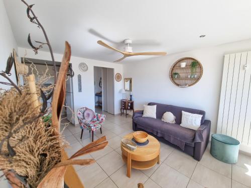 a living room with a couch and a table at Les Iris T2 en centre ville in Le Lavandou