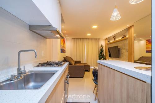 una cucina con lavandino e piano cottura di Excelente apto luxuoso a 3 min da praia DBR0805 a Itapema