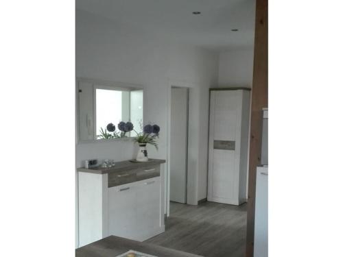 uma cozinha branca com um lavatório e um espelho em Appealing apartment in Lübbenau em Lübbenau