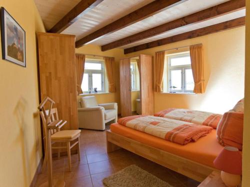 ein Schlafzimmer mit einem Bett und einem Stuhl in einem Zimmer in der Unterkunft Majestic apartment in Pellworm in Pellworm