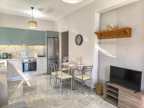 a kitchen with a table and chairs and a television at Newly Built House Steps from the Beach: Everything Within Walking Distance - Enjoy a Car-Free Stay in Agia Marina Nea Kydonias
