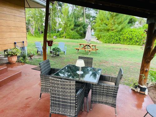 a patio with a table and chairs and an umbrella at Bungalow TEIPO in Teavaro