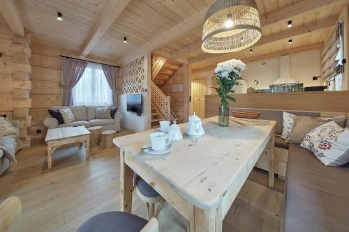 una sala de estar con una gran mesa de madera en una cabaña en Chochołóvka, en Chochołów