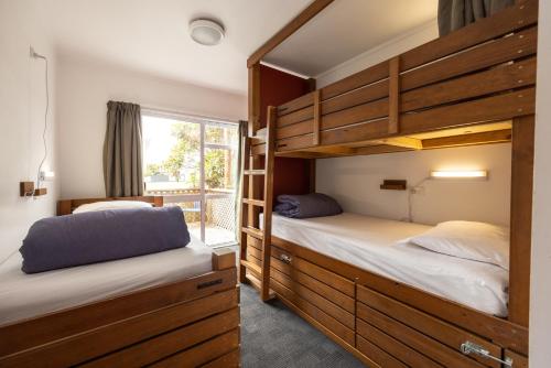 two bunk beds in a room with a window at Haka Lodge Taupo in Taupo