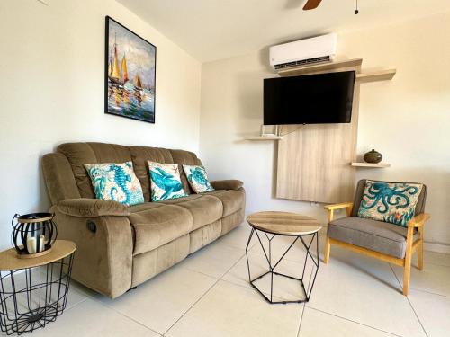 a living room with a couch and a chair at Parakeet Paradise 2nd Floor Condo With Rooftop in Coco