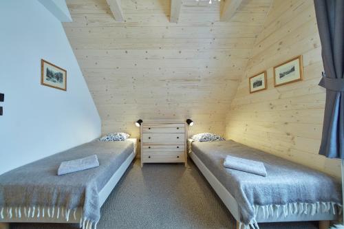 a bedroom with two beds in a log cabin at Chochołóvka in Chochołów
