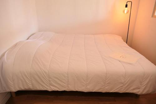 Ce lit se trouve dans un dortoir doté d'un couvre-lit blanc. dans l'établissement Résidence Les Dryades - Les Dryades 13 MAE-9564, à Saint-Gervais-les-Bains