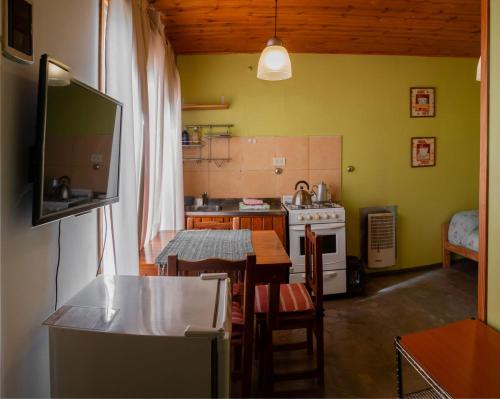 a kitchen with a table and a kitchen with a television at Cabañas Costa del Percy in Trevelin