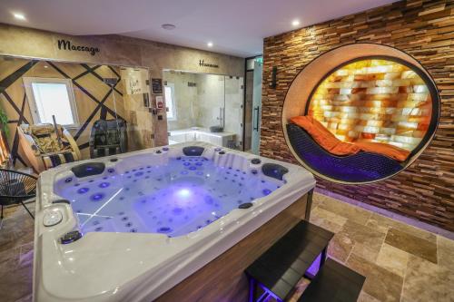 a jacuzzi tub in the middle of a room at O'SPA 25 - Bien Etre et Détente in Montbéliard