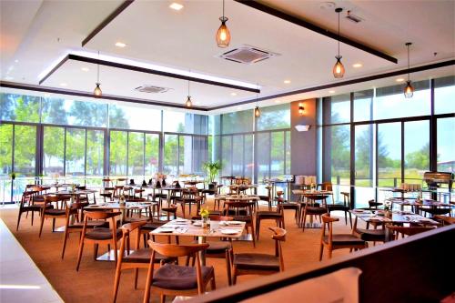 a restaurant with tables and chairs and large windows at PD Seaview Sunset Cozy Staycation With Pool & Netflix, Private Unit in Port Dickson