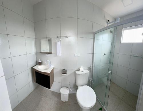 a white bathroom with a toilet and a sink at Pousada Hércules Beach Paradise in Maragogi