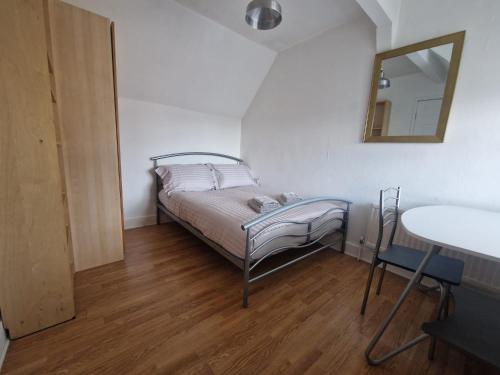 a small bedroom with a bed and a mirror at Suite 3: Homely Room near Sheffield CC in Sheffield