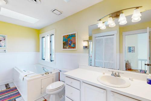 uma casa de banho com um lavatório, um WC e um espelho. em Mystic Heights em Emerald Isle