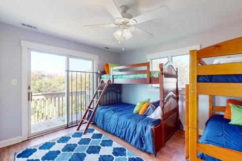 a bedroom with bunk beds and a balcony at Mystic Heights in Emerald Isle