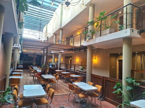 un restaurante con mesas, sillas y plantas en Atardeceres Apartments en Cañuelas