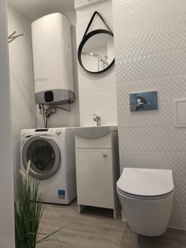 ein Badezimmer mit einer Waschmaschine und einem Waschbecken in der Unterkunft Apartament Pułaskiego 11m8 - Centrum Sopotu 1 min do Monciaka in Sopot