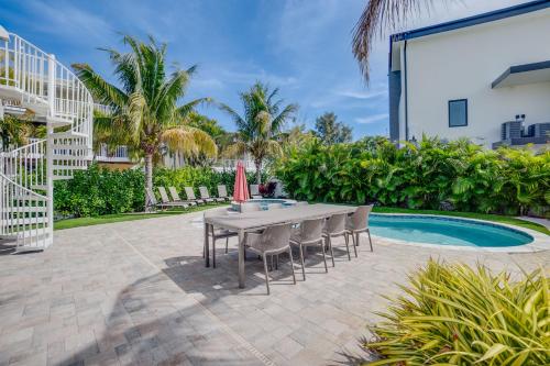 a patio with a table and chairs next to a pool at Approx 40 steps to beach entrance of Anna Maria beach in Anna Maria
