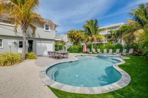 a swimming pool in a yard with a table and chairs at Approx 40 steps to beach entrance of Anna Maria beach in Anna Maria