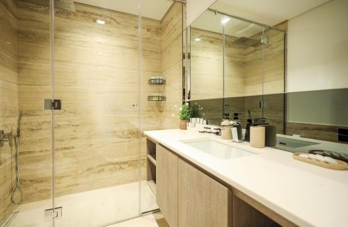 Elite LUX Holiday Homes - Elegant 2BR Suite in Business Bay Dubai في دبي: حمام مع حوض ودش