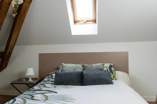 a bedroom with a bed with pillows and a window at Chez Nous Laval in Laval