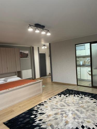 an empty bedroom with a bed and a rug at Eben ezer concept in Târgu-Mureş