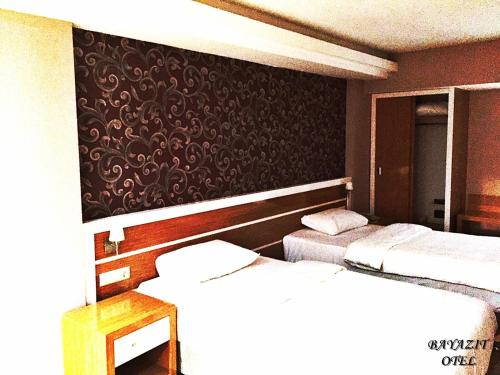a room with two beds and a black wall at Bayazıt Hotel in İskenderun