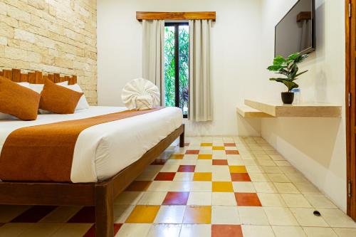 a bedroom with a bed and a checkered floor at Hotel Boutique Casa Hipil in Valladolid