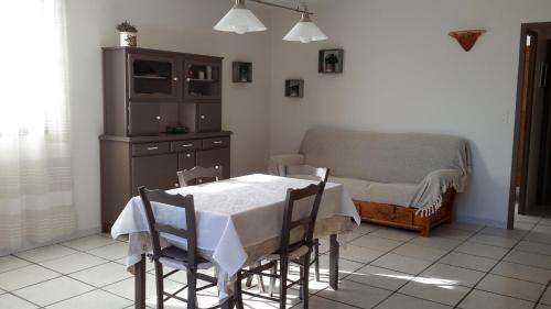 une salle à manger avec une table et un canapé dans l'établissement Appartement à la campagne, à Aiglun