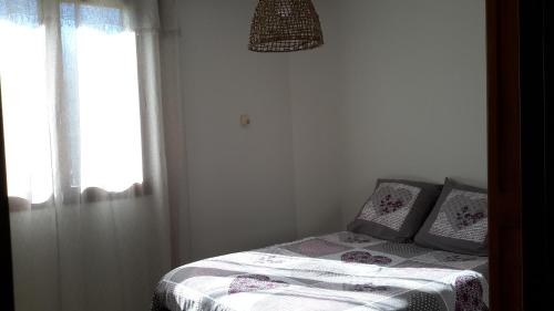 Dormitorio pequeño con cama y ventana en Appartement à la campagne en Aiglun