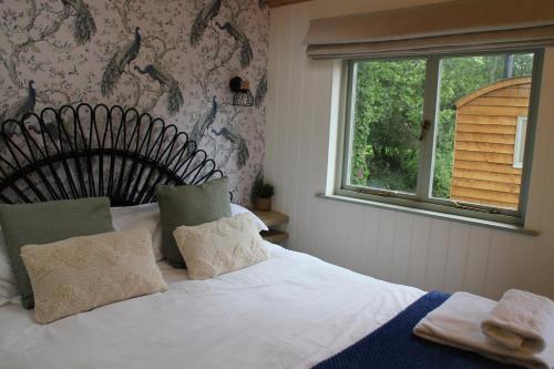 a bedroom with a white bed with a window at The Apple Inn in Lucker