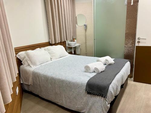 um quarto com uma cama com toalhas em Saboresgelados Alojamento Local em Braga