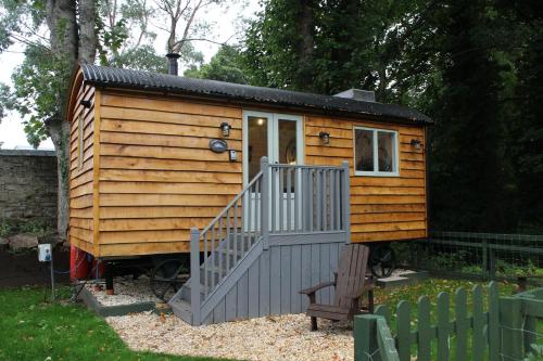 a small wooden cabin with a staircase in a yard at The Apple Inn in Lucker