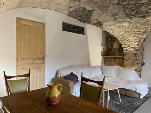 a room with a table and chairs and a bed at La Crémesine in Baratier