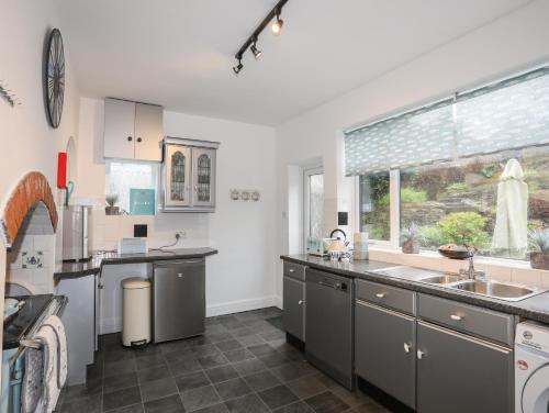 a kitchen with stainless steel appliances and a window at Casita in Benllech