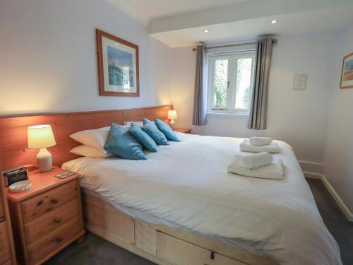 a bedroom with a large white bed with blue pillows at Troutbeck in Ambleside