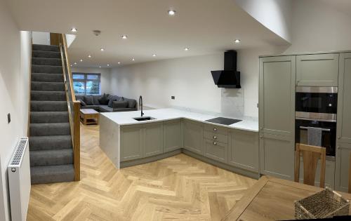 une cuisine avec un escalier et un salon dans l'établissement Bryn Glo Cottage, à Capel-Curig